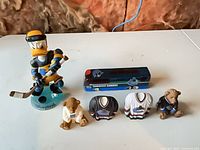 Full lot: Donald Duck bobblehead, die-cast bus, two bear figurines, two jersey figurines