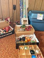 Overview of ornaments in boxes, wrapping paper roll, blue storage tote