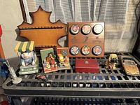 Overall lot showing plaques, pig bank, model car, playing card box, figurines