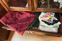 Drawer with red damask cloth, stack of assorted linens