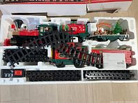 Tray showing locomotive, tender, boxcar, flatcar with tree, caboose, track sections, control unit