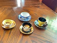 Four teacup and saucer sets on wooden table