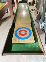 Full length view of wooden shuffleboard table with green felt gutters