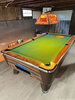 Valley pool table three-quarter view showing woodgrain cabinet, green cloth and chrome corners