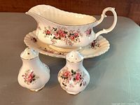 Gravy boat on underplate with salt and pepper shakers front view