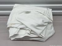 Folded white Au Lit king sheets showing label and fabric