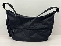Front view of black nylon Derek Alexander hobo bag showing exterior front zip pocket and overall shape