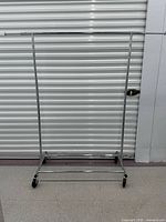 Full view of chrome metal garment rack on casters