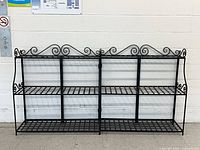 Pair of black wrought iron folding shelves side-by-side