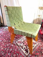 Front angle view of chair showing green webbing and plywood frame