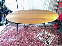 Full view of assembled rosewood oval dining table on chrome legs