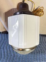 White milk glass pendant with brown canopy and wiring