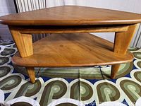 Front view of triangular two-tier coffee table showing both shelves and legs