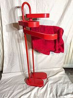Side view of red freestanding rack with towel to show scale and design