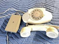 Telephone, handset, cord and external ringer on padded surface