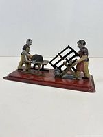 Side view of mechanical tin lumber workshop toy