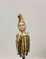 Front view of bisque head jester marotte doll on stick