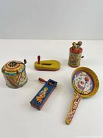 All five lithographed tin noisemakers front view