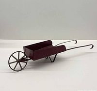 Full view of miniature metal wheelbarrow, left side perspective