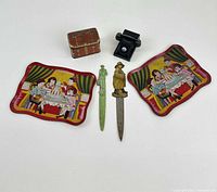 All six items laid out – two trays, tin box, telephone toy, two letter openers