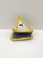 Straw sailboat front view showing sail, deck, and yellow edging