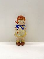 Front view of ceramic Dutch girl doll figurine standing upright