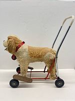 Left side view of plush dog on wheeled push frame showing overall construction and materials