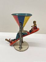 Full view of Busy Mike tin sand toy showing funnel, seesaw, figures and base