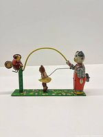 Full view of wind-up skip rope toy showing all three figures and base