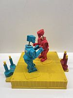 Full view of yellow ring with red and blue robots facing each other