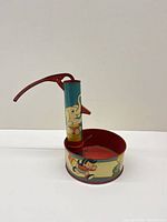 Full view of Ohio Art tin litho pump toy with basin and handle