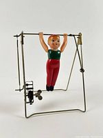 Front view of wind-up gymnast on frame