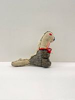 Left profile of grey and cream wool dinosaur plush, shows size and texture