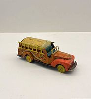 Side view of litho tin fire truck showing tanker body, ladders, wheels, and cab