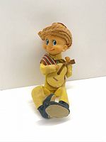 Front view of seated TKR Japan doll holding guitar