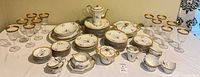 Overall view of entire Limoges dinnerware set and stem glasses