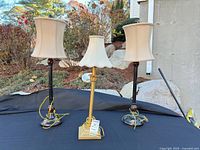 front view of three table lamps on table outdoors