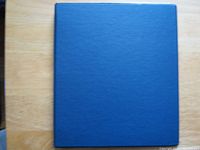 Closed blue binder on tabletop