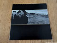 Front of gatefold jacket featuring band against desert landscape