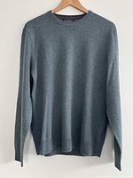Front view of heather green cashmere sweater hanging on hanger