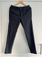 Full front view of black pants on hanger