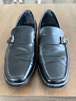 Top view of both loafers showing buckle strap, toe shape, overall condition