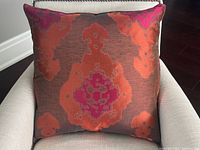 Front view of the pillow on chair showing overall design and colors