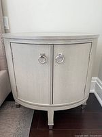 Front view of oval side table showing two ring pulls and tapered legs
