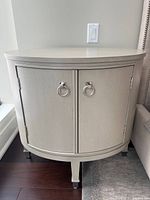 Front view of oval side table showing two doors with ring pulls