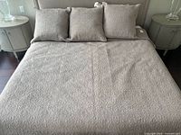 Bed shown with taupe quilted linen coverlet and three matching pillow shams