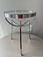 Full view of the round glass top side table showing chrome base and overall form
