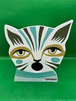 Front view showing painted cat face design and entrance hole