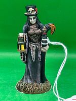 Front view of Madame Laveau figurine showing lantern, staff, clothing detail