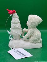 Front view of Snowbabies figurine with tree and cardinal